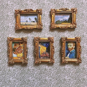 May include: Five framed miniature paintings in ornate gold frames. The paintings depict scenes from Van Gogh's artwork, including sunflowers, landscapes, and self-portraits. The frames are hung on a patterned wallpaper background.