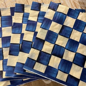 May include: Set of five blue and white checkered paper napkins. The napkins have a watercolor-like design with a slightly faded look.