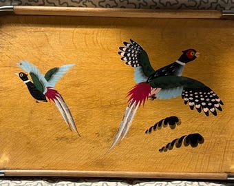 May include: Wooden serving tray with a light brown finish, featuring two painted pheasants in flight. The birds have black, green, red, and blue details. The tray has a metal rim and wooden handles.