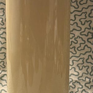 May include: A vintage Thermos flask in cream and burgundy. The top and base are burgundy, with a cream-coloured body. The word "THERMOS" is printed on the top, and "Tim Hortons" is printed on the bottom.