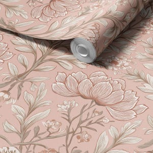 May include: A roll of wallpaper with a floral design. The pattern features large, stylised flowers and leaves in shades of brown and cream against a soft pink backdrop. The wallpaper is unrolled, showing the repeating pattern.
