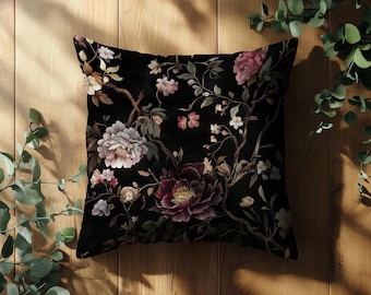 May include: Black pillow with a floral pattern featuring pink, white, and burgundy flowers on a black background.