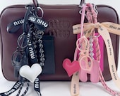 miu miu レッド ポンポンチャーム Miu Miu ロゴチャーム ブレスレット | ブラック | FARFETCH JP