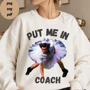 May include: White sweatshirt with a black graphic print of a man in a tutu with the text "Put Me In Coach".