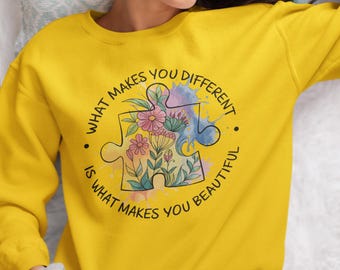 May include: Yellow sweatshirt with a black and white graphic of a puzzle piece with flowers inside. The text around the puzzle piece reads "What makes you different is what makes you beautiful."