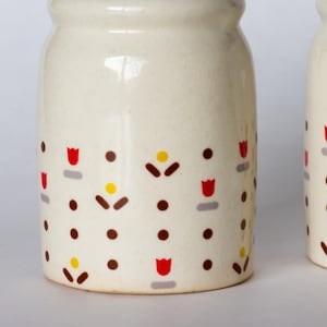 Salero y pimentero de cerámica con diseño de margaritas de mediados de siglo, con estampado floral marrón, rojo y amarillo, de MCM