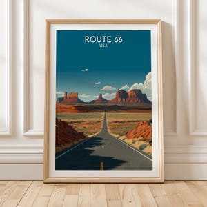 Könnte beinhalten: Gerahmter Kunstdruck mit einer Landschaft der Route 66 in den USA. Das Kunstwerk zeigt eine Straße, die zum Horizont führt, mit roten Felsformationen und blauem Himmel. Der Text "ROUTE 66 USA" ist oben zu sehen.