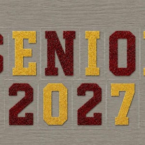 May include: Glittery maroon and gold letters spell "SENIOR 2027" on a gray background. The letters are individual, with a clear backing. The word "SENIOR" is in maroon, and the numbers "2027" are in gold.