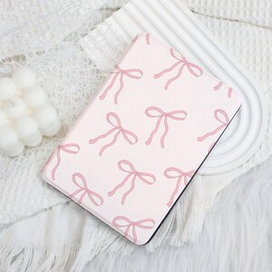 May include: A pink e-reader cover with a pattern of pink bows.