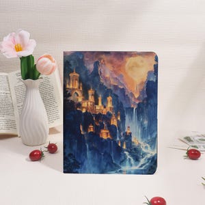 Könnte beinhalten: Ein Fantasy-Kunstdruck mit einem Schloss in einem Gebirge mit Wasserfällen. Das Kunstwerk verwendet Blau- und Goldtöne, mit einem Vollmond im Hintergrund. Das Schloss ist mit warmem Licht beleuchtet.