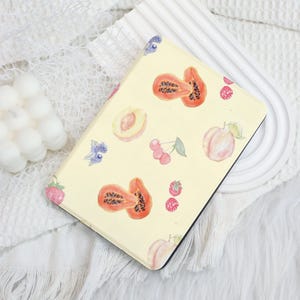 May include: A yellow notebook cover with a repeating pattern of papaya, peach, and berries. The design is in a watercolor style.