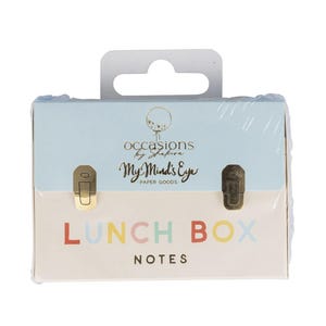 May include: A light blue and cream-colored lunch box with the words "LUNCH BOX NOTES" in colorful letters. The box has a handle and two metal clasps. The top of the box has the text "occasions by shakira" and "My Mind's Eye PAPER GOODS".