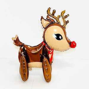 May include: A brown and gold reindeer balloon with a red nose and a red bow. The balloon is standing on all fours and has a cute cartoon face.