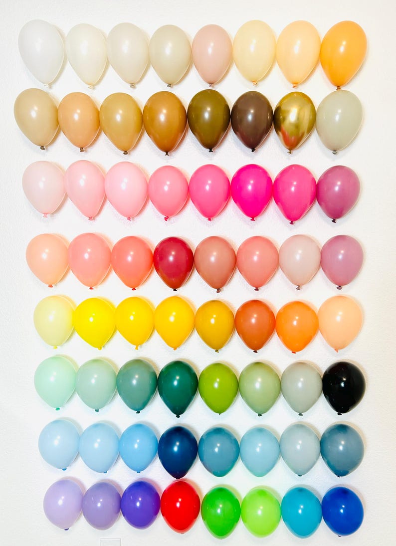 Puede incluir: Un arco&iacute;ris de colores en una colecci&oacute;n de 10 filas de 10 globos. Los globos est&aacute;n dispuestos en un degradado de blanco a morado.