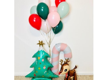 Può includere: Un'allegra composizione di palloncini natalizi con palloncini rossi, verdi, rosa e bianchi. Include un albero di Natale verde, un bastoncino di zucchero e un palloncino a forma di renna, ideale per le decorazioni natalizie.