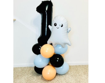 May include: A black number one balloon with a white ghost balloon with a smiling face. The balloons are surrounded by smaller balloons in black, orange and light blue.