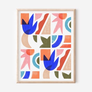 May include: Abstract art print with a geometric pattern in shades of blue, pink, orange, and green. The print is framed in a light wood frame.