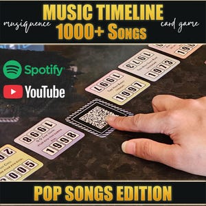 May include: A Musiquence music timeline card game featuring over 1000 songs in a Pop Songs Edition. The game includes square cards with song titles, release years, and QR codes for Spotify and YouTube integration, displayed on a dark surface.