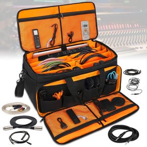May include: Black and orange travel bag with multiple compartments and pockets, filled with various cables, microphones, and other audio equipment.