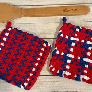 May include: Two red, white, and blue woven pot holders. The pot holders are square shaped and have a woven pattern.