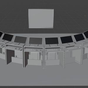Puede incluir: Una fila curva de estaciones de trabajo informáticas grises con pantallas negras, dispuestas en semicírculo. Las estaciones de trabajo están instaladas frente a una gran pantalla gris en blanco.