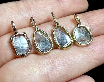 Puede incluir: Cuatro colgantes de tono dorado con piedras de cuarzo transparentes. Las piedras están talladas en diferentes formas y tamaños, y los colgantes tienen un diseño de cuerda alrededor de los bordes.