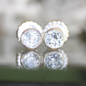 May include: A pair of silver stud earrings with clear round gemstones.