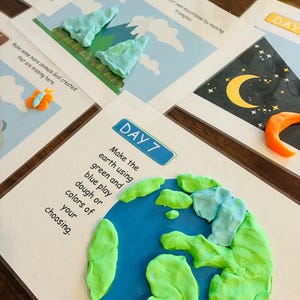 May include: A craft activity with printed instructions and colorful playdough. The image shows a globe made of green and blue playdough, with instructions to make the earth. Other pages show mountains and animals.