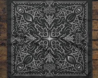 May include: Dark grey square bandana featuring a detailed, symmetrical pattern in light grey. The design incorporates floral elements, skulls, crosses, and the text "Deluxe Dragstrip" and "MCDVIII". The bandana is shown on a wooden surface.