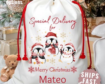 May include: A white Christmas gift bag with a red drawstring features three penguins wearing Santa hats and scarves. The text "Special Delivery for Merry Christmas Mateo" is printed in red. The bag has a "Ships Fast From USA" sticker.