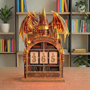 Pode incluir: Um balcão decorativo em forma de estante com um design de dragão e castelo. O balcão tem um visor que mostra o número "365" e o texto "Books Read This Year" e "Olivia's Library". O dragão tem detalhes em laranja e amarelo.