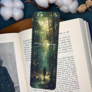 Könnte beinhalten: Ein Aquarellgemälde eines Waldweges mit einer einzelnen Figur, die durch die Bäume geht. Der Weg ist von Bäumen gesäumt und das Licht scheint durch die Blätter. Das Gemälde ist in einem dunklen Grün- und Braunton gehalten. Die Signatur "Kerry Moreau" ist in der linken unteren Ecke sichtbar.