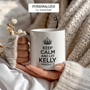 May include: White ceramic mug with a black crown and the text "Keep Calm and Let Kelly Handle It".