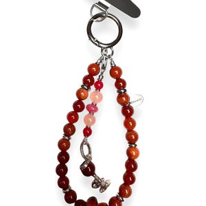 May include: A red, orange and pink beaded keyring with a silver charm of a wine glass. The keyring is attached to a silver ring.