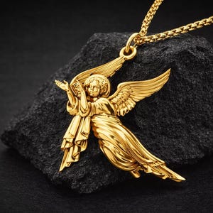 Puede incluir: Un collar con colgante de &aacute;ngel dorado. El colgante presenta un &aacute;ngel con alas extendidas y t&uacute;nicas fluidas. El collar se exhibe sobre una roca oscura y texturizada sobre un fondo negro.