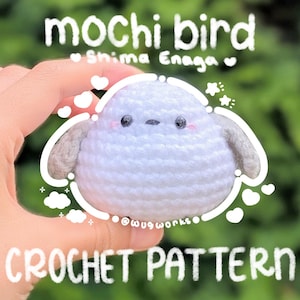 Puede incluir: Un pájaro de ganchillo blanco hecho a mano con alas grises y una cara linda. La imagen incluye el texto "mochi bird" y "CROCHET PATTERN". El pájaro tiene mejillas rosadas y ojos negros. El fondo es verde borroso.