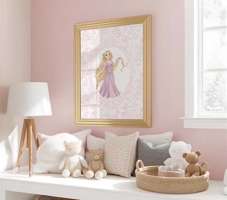May include: A framed print featuring a princess in a pink dress with long blonde hair. The artwork is set against a pink floral background and framed in gold. The scene is in a child's bedroom with stuffed animals and a lamp.