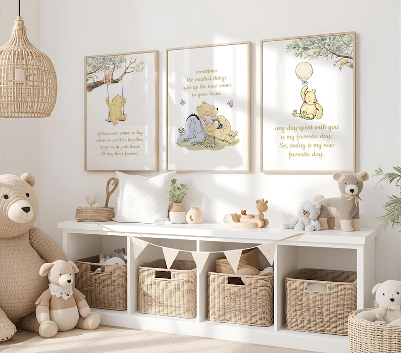May include: Three framed Winnie the Pooh art prints with quotes in a nursery setting. The prints feature illustrations of Pooh and friends. The room includes a white shelf with woven baskets, stuffed animals, and decorative items.