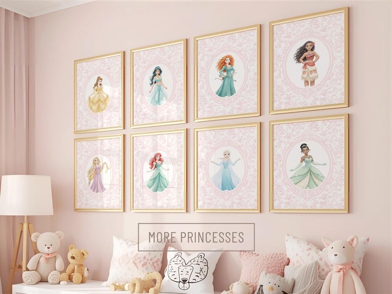 May include: Nine framed princess art prints with gold frames are displayed on a pink wall. Each print features a princess illustration within a pink oval, surrounded by a decorative border. The text "MORE PRINCESSES" is below the frames.