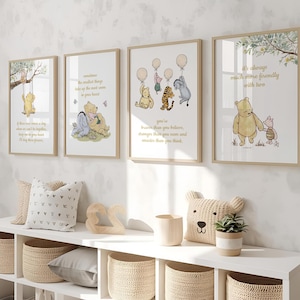 May include: Four framed Winnie the Pooh art prints with inspirational quotes and illustrations. The prints feature characters like Pooh, Piglet, and Tigger. The frames are a light wood color, and the artwork is displayed on a white wall.