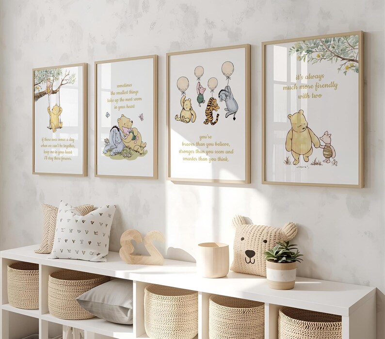 May include: Four framed Winnie the Pooh art prints with inspirational quotes and illustrations. The prints feature characters like Pooh, Piglet, and Tigger. The frames are a light wood color, and the artwork is displayed on a white wall.