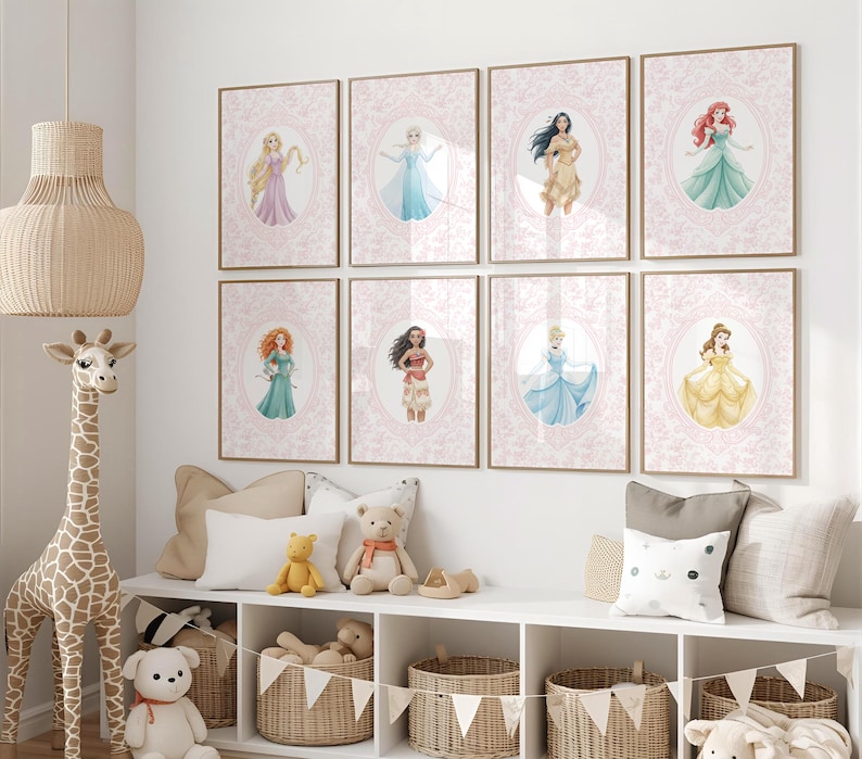 May include: A collection of eight framed art prints featuring watercolor illustrations of fairytale princesses. Each print has a pink floral background and a gold frame. The princesses are depicted in their iconic gowns and poses.
