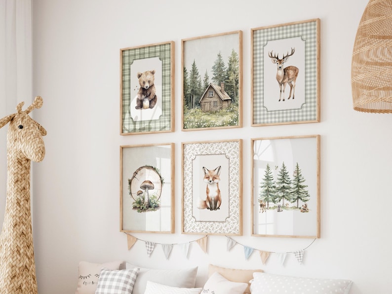 May include: Six framed art prints with woodland animal and forest scenes. The prints feature a bear, a cabin, a deer, a fox, a mushroom, and trees. The frames are light brown, and the artwork has a watercolor style with green and brown tones.