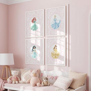 May include: Four framed princess art prints. Each print features a different princess in a watercolor style, set against a pink floral background. The princesses are in dresses of various colors, including blue, green, and yellow.