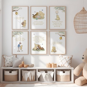 May include: A set of six framed Winnie the Pooh art prints with quotes. The prints feature illustrations of Pooh, Tigger, and Piglet. The prints are displayed above a white shelf with baskets, pillows, and a wooden toy.