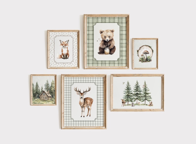 May include: A collection of framed watercolor art prints featuring woodland animals and forest scenes. The prints include a fox, bear, deer, cabin, mushrooms, and trees. Each print is in a wooden frame with a decorative border.