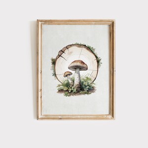 May include: Watercolor painting of two mushrooms with brown caps and white stems, growing in a bed of green moss and grass. The mushrooms are set against a backdrop of a tree trunk slice, all within a wooden frame.