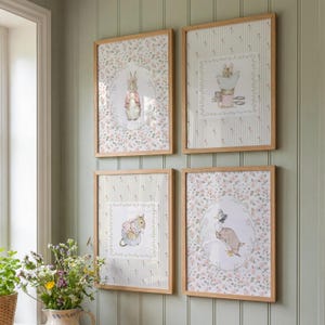Peut inclure: Quatre impressions d'art encadr&eacute;es avec des illustrations de personnages de contes de f&eacute;es. Les impressions sont dans des cadres en bois clair, mont&eacute;es sur un mur vert. L'&oelig;uvre comprend un lapin, un canard et une souris, entour&eacute;s de motifs floraux et ray&eacute;s.