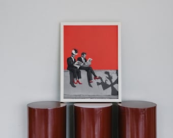 May include: A framed print of two people sitting on a ledge, reading a newspaper. The background is a solid red color. The people are wearing suits and red shoes. Their shadows are cast on the ledge below them.