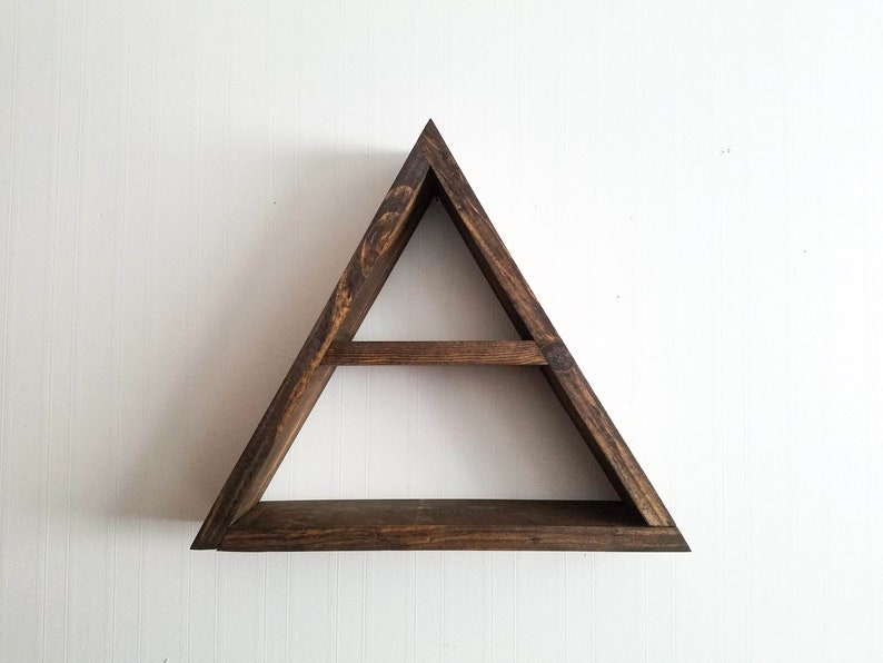 May include: A triangular wooden shelf with two shelves. The shelf is stained a dark brown color and has a rustic look.